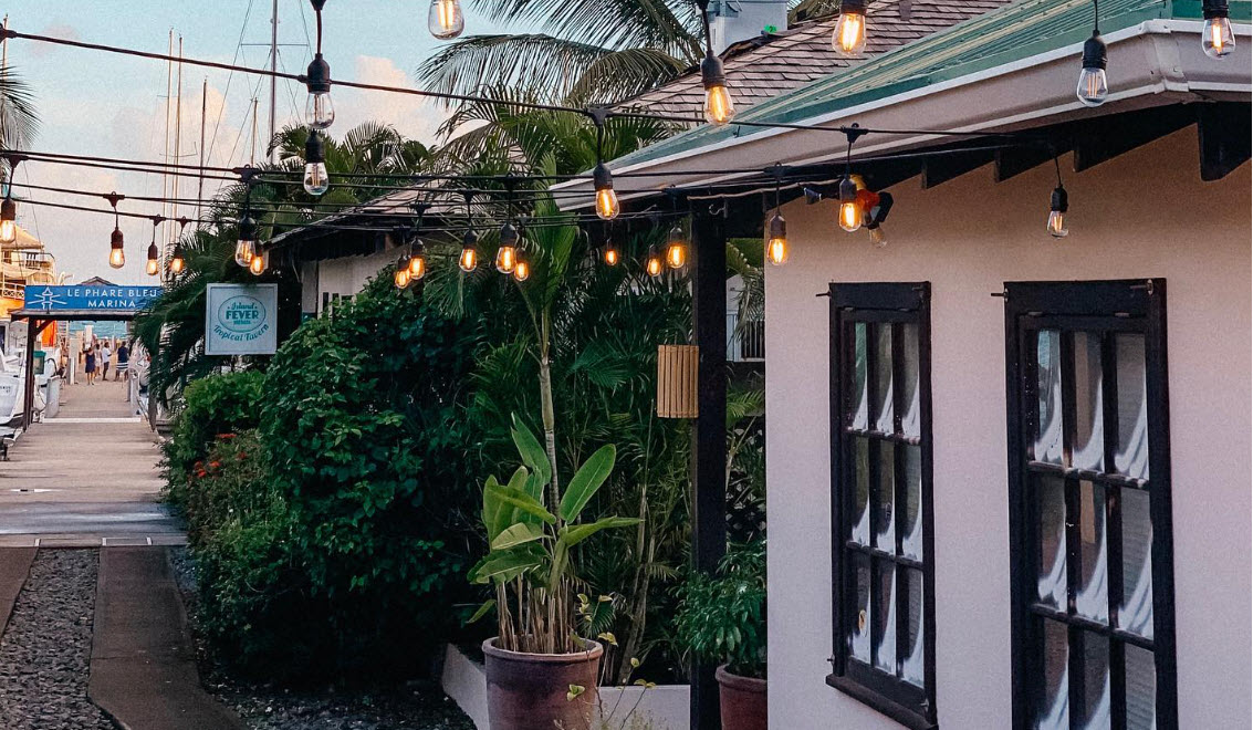 Le Phare Bleu mini market with evening string lights at best places for investment properties
